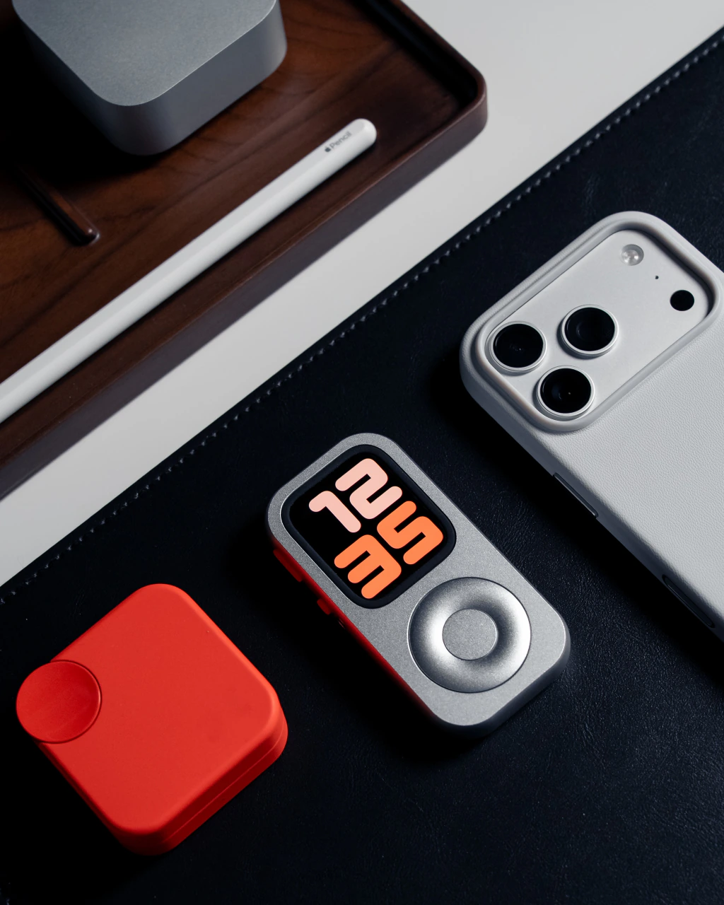RePod con un reloj naranja en pantalla junto a un teléfono y accesorios de escritorio.